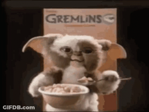 A Stuffed Animal Is Holding A Bowl Of Cereal . GIF