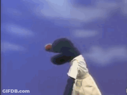 A Stuffed Animal Is Holding A Football In Its Mouth . GIF