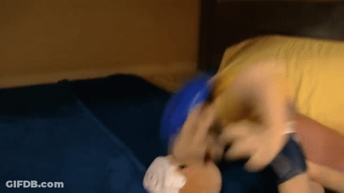 A Stuffed Animal Is Laying On A Bed With A Bandage On Its Head . GIF
