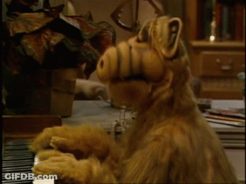 A Stuffed Animal Is Playing A Piano With Its Mouth Open GIF