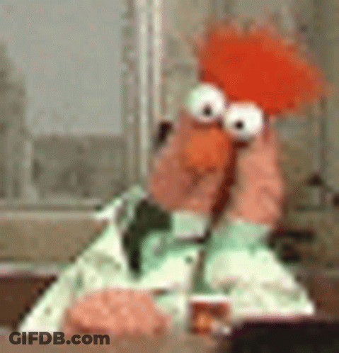 A Stuffed Animal Is Sitting At A Table Holding A Stuffed Animal In Its Hands . GIF