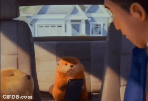A Stuffed Animal Is Sitting In The Back Seat Of A Car With A Man Looking At It GIF