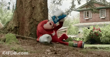 A Stuffed Animal Is Sitting Under A Tree In Front Of A House Wearing A Wizard 'S Hat . GIF
