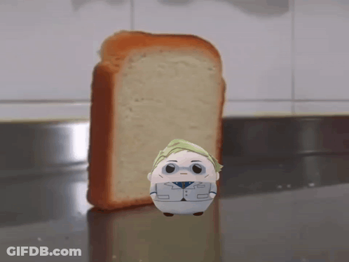 A Stuffed Animal Is Standing In Front Of A Loaf Of Bread GIF