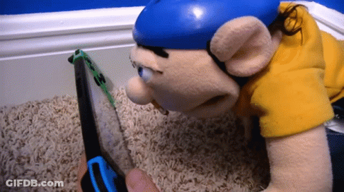 A Stuffed Animal Laying On The Floor Looking At A Nintendo Switch GIF