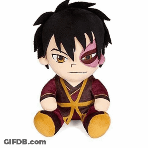 A Stuffed Animal Of A Boy With Black Hair And A Red Eye Is Sitting On A White Surface . GIF