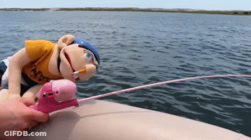 A Stuffed Animal On A Boat With A Fishing Rod And A Cigarette In Its Mouth GIF