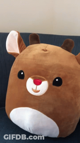 A Stuffed Animal That Looks Like A Reindeer With A Red Nose GIF