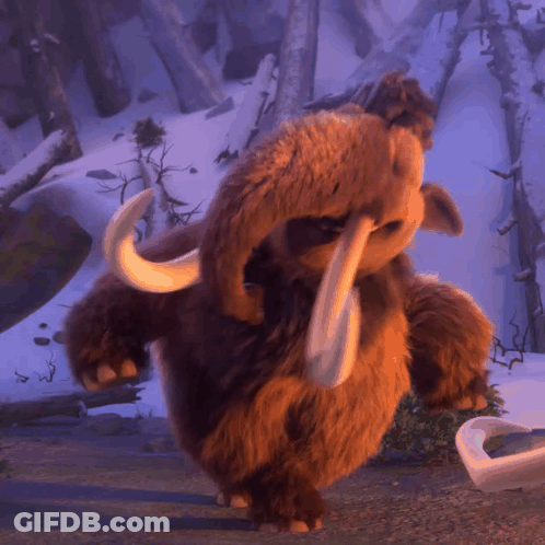 A Stuffed Animal That Looks Like An Elephant With Tusks Standing In The Snow GIF