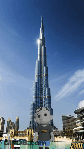 A Stuffed Animal Wearing A Shirt That Says Zhot Stands In Front Of A Dubai Skyscraper GIF