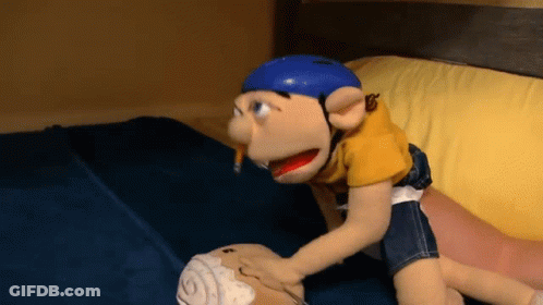 A Stuffed Animal With A Blue Helmet On Is Laying On A Bed GIF