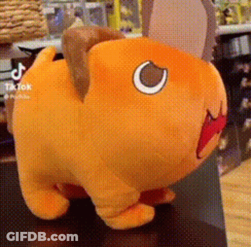 A Stuffed Animal With A Red Mouth Is Sitting On A Table . GIF