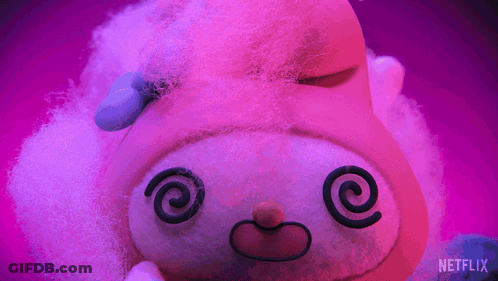 A Stuffed Animal With A Swirl In Its Eyes Is On A Purple Background With A Netflix Logo In The Corner GIF