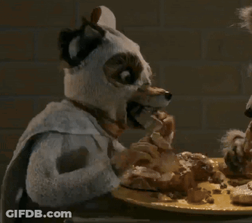 A Stuffed Animal With A Towel Around Its Neck Eating A Piece Of Food GIF
