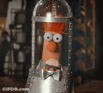 A Stuffed Animal With Big Eyes And A Cupcake In His Mouth GIF