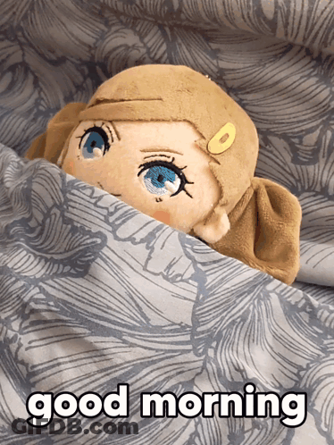 A Stuffed Animal With Blue Eyes Is Laying Under A Blanket With The Words Good Morning Below It GIF