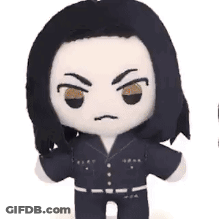 A Stuffed Animal With Long Black Hair And Brown Eyes Is Making A Funny Face . GIF