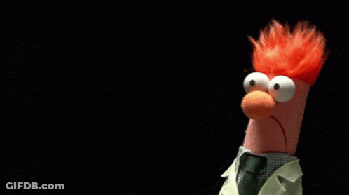A Stuffed Animal With Red Hair And Big Eyes Is Wearing A Lab Coat And Tie GIF