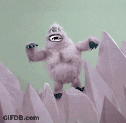 A Stuffed Animal With Sharp Teeth Is Standing On Top Of A Pile Of Ice GIF