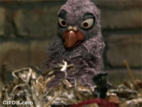 A Stuffed Bird Is Eating Popcorn From A Red And White Box GIF