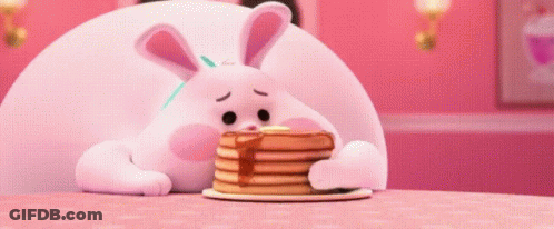 A Stuffed Bunny Is Eating A Stack Of Pancakes . GIF