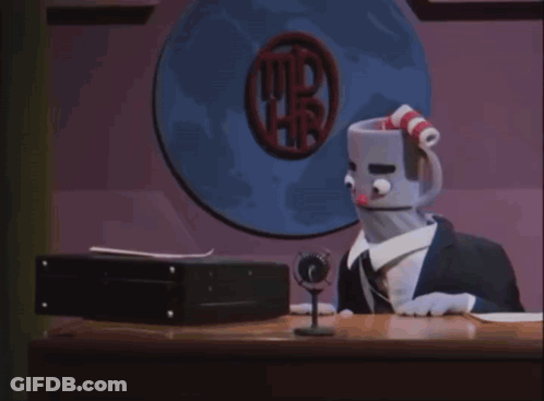 A Stuffed Cuphead Is Sitting At A Desk In Front Of A Computer Screen GIF