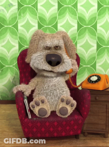 A Stuffed Dog Sits In A Chair Talking On A Phone GIF