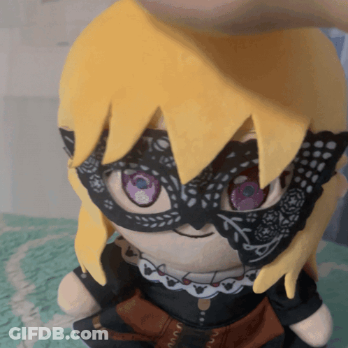 A Stuffed Doll Wearing A Mask And A Necklace GIF