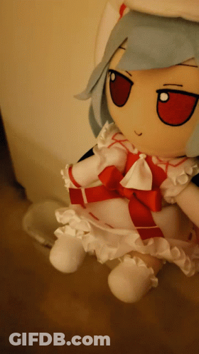 A Stuffed Doll With Blue Hair And A Red Bow GIF