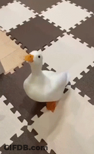 A Stuffed Duck With A Yellow Beak Is Walking On A Puzzle Mat GIF