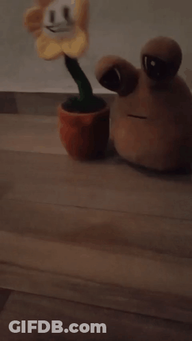 A Stuffed Flower With A Green Stem Is Laying On The Floor GIF