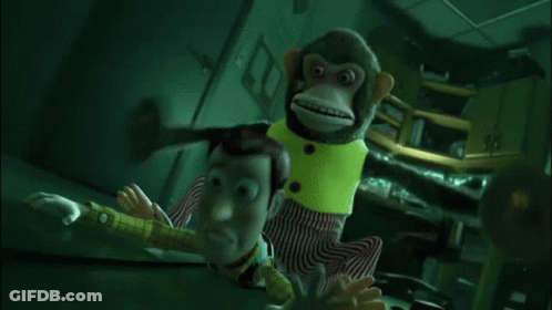 A Stuffed Monkey Is Holding Buzz Lightyear In A Room . GIF