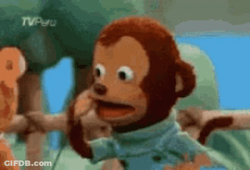 A Stuffed Monkey Is Making A Funny Face And Talking On A Cell Phone . GIF