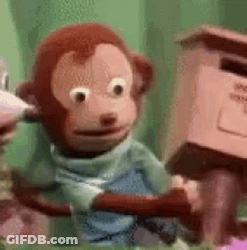 A Stuffed Monkey Is Sitting On A Tree Branch Next To A Pink Mailbox . GIF