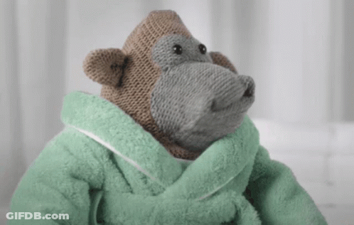 A Stuffed Monkey Wearing A Green Towel Around His Neck GIF