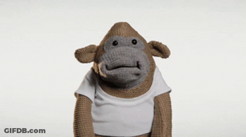 A Stuffed Monkey Wearing A White Shirt Is Making A Surprised Face GIF