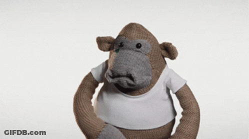 A Stuffed Monkey Wearing A White T-Shirt Looks Confused GIF