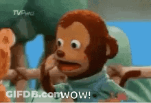 A Stuffed Monkey With A Surprised Look On His Face Is Talking On A Cell Phone . GIF