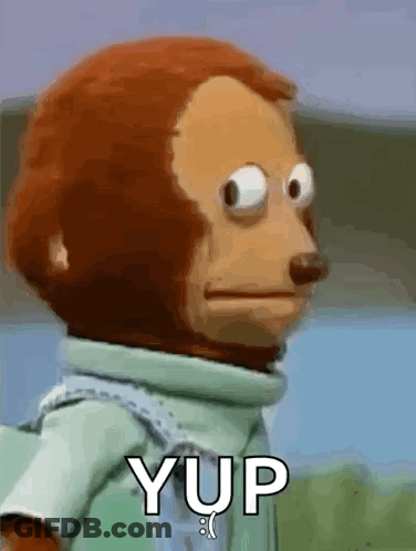 A Stuffed Monkey With Big Eyes Is Standing In Front Of A Sign That Says Yup . GIF