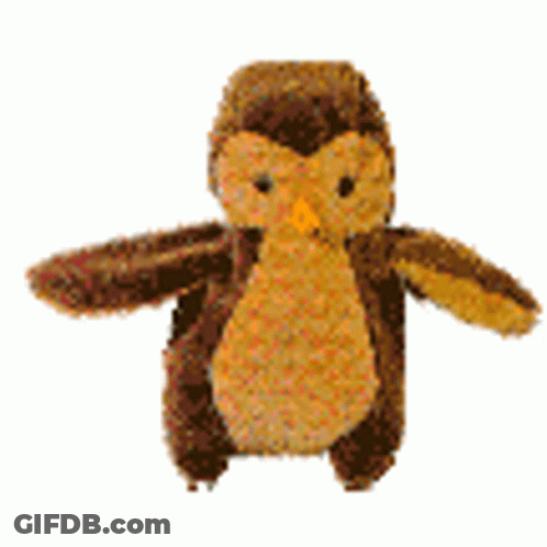 A Stuffed Owl With Wings Is Sitting On A White Surface . GIF