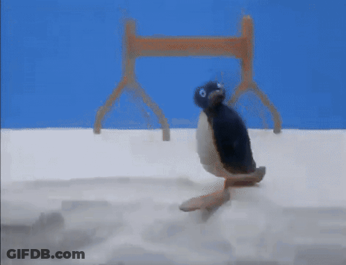 A Stuffed Penguin Is Crawling On A White Surface . GIF