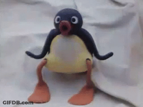 A Stuffed Penguin Is Sitting On A White Cloth GIF