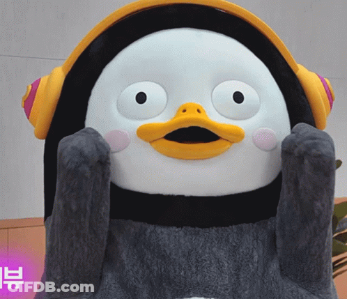 A Stuffed Penguin Wearing Headphones Has A Yellow Beak And A Black Body GIF