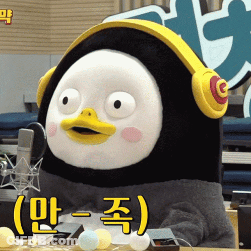 A Stuffed Penguin Wearing Headphones With Korean Writing GIF