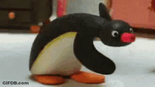 A Stuffed Penguin With A Pink Nose Is Standing On A White Surface . GIF