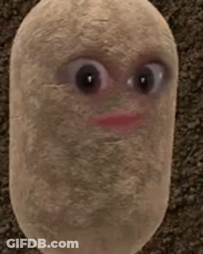 A Stuffed Potato With Big Eyes And A Red Lip Is Sitting On A Carpet . GIF