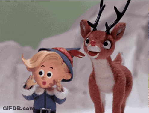 A Stuffed Reindeer Standing Next To A Cartoon Character GIF
