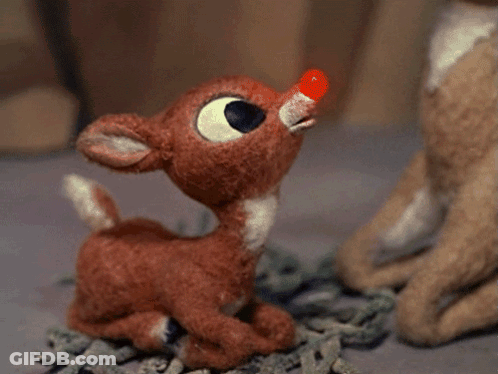 A Stuffed Reindeer With A Red Nose Looks Up GIF