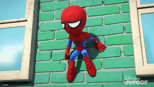A Stuffed Spider Man Is Hanging On A Green Brick Wall From Disney Junior GIF