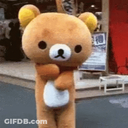 A Stuffed Teddy Bear Is Standing In Front Of A Store GIF